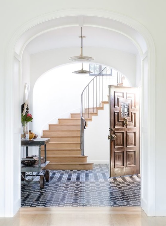 navy and white mosaic tiles in the entryway and a sharp transition to neutral laminate in the rest of the space