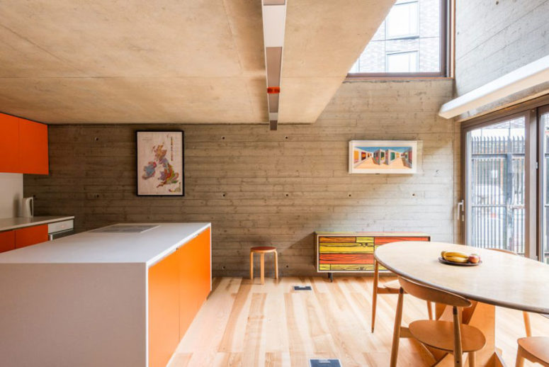 This industrial loft with an open plan and bold orange touches was designed for a bachelor