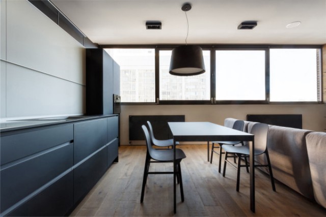 Warm woods and brown shades make the apartment more inviting and cozy, and the windows are big enough to let a lot of light in