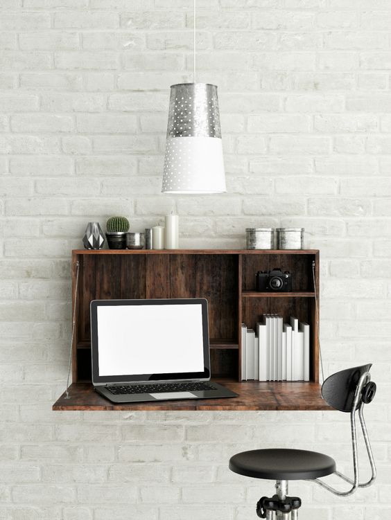 a wall mounted desk of reclaimed wood accomodates a laptop
