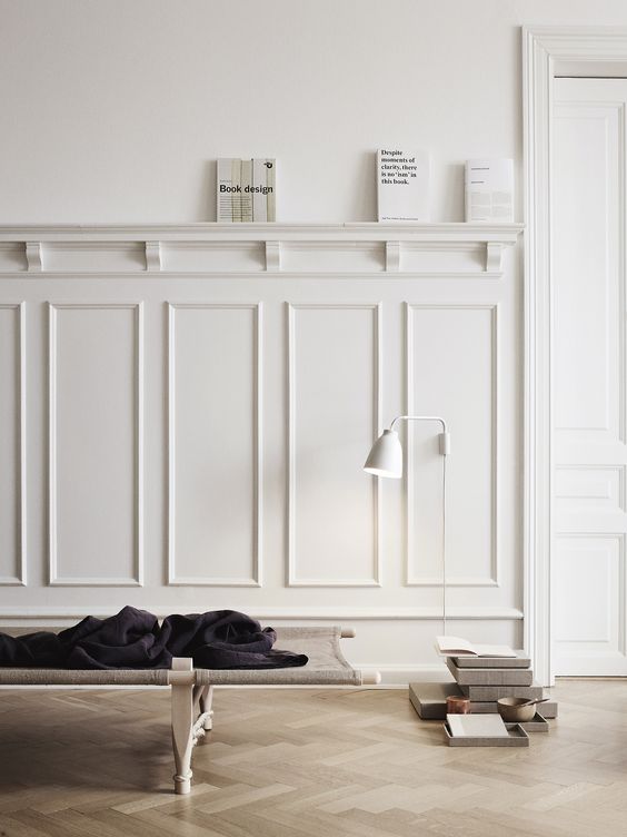 modern minimalist living room with tall wainscoting and a shelf on its top