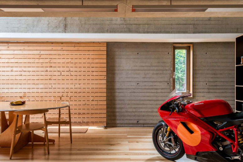 The dining area is clad with light warm-colored wood, and the dining set is also of the same wood