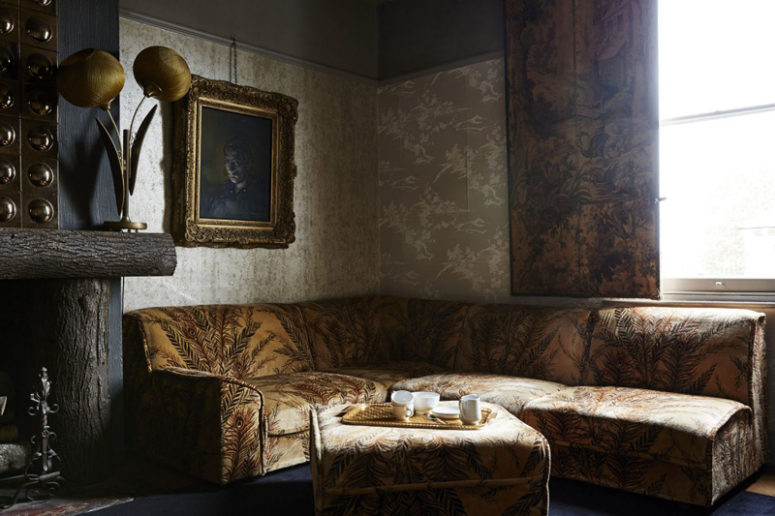 Another living space is also antique, in ocher and yellow, the fireplace is clad with rough wood