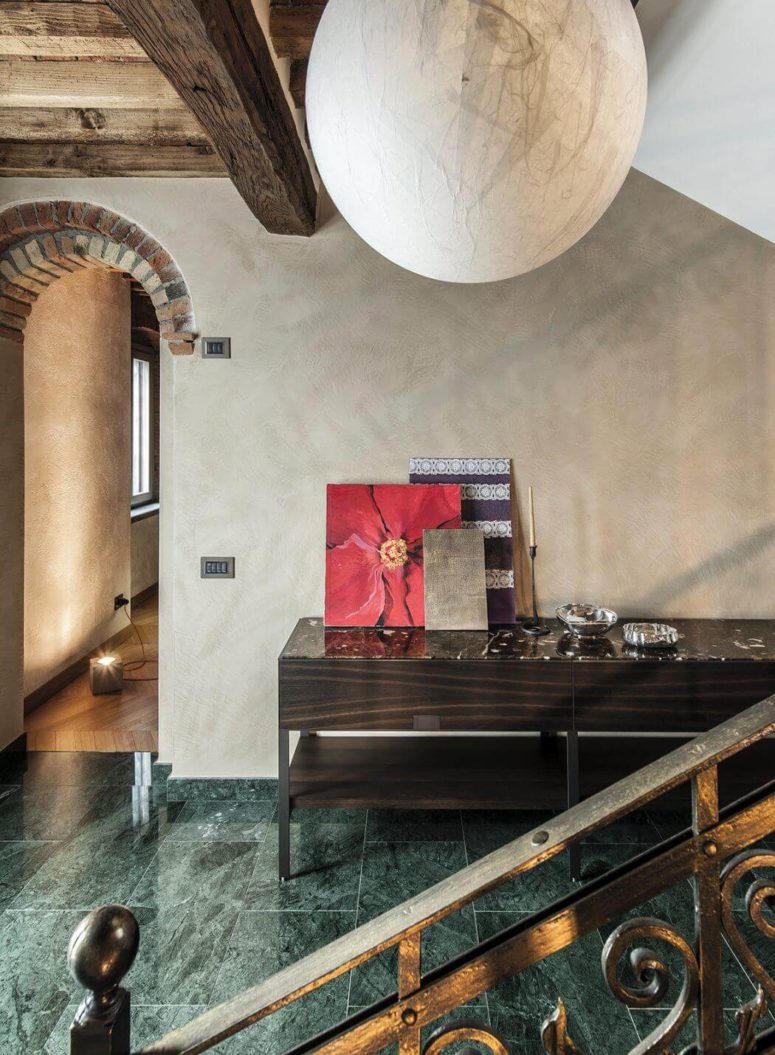 Green tiles with a marble print and a dark sideboard make this hallway refined