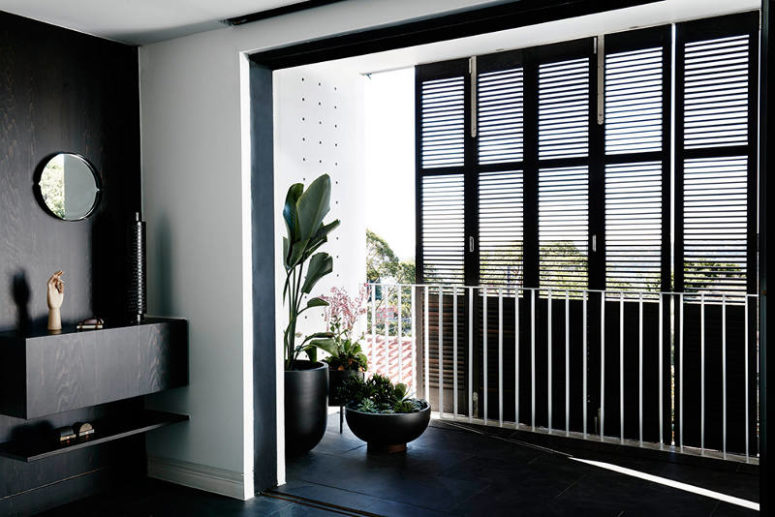 Inside you'll see a mix of white and dark wood and dark tiles, which give this home a minimalist look