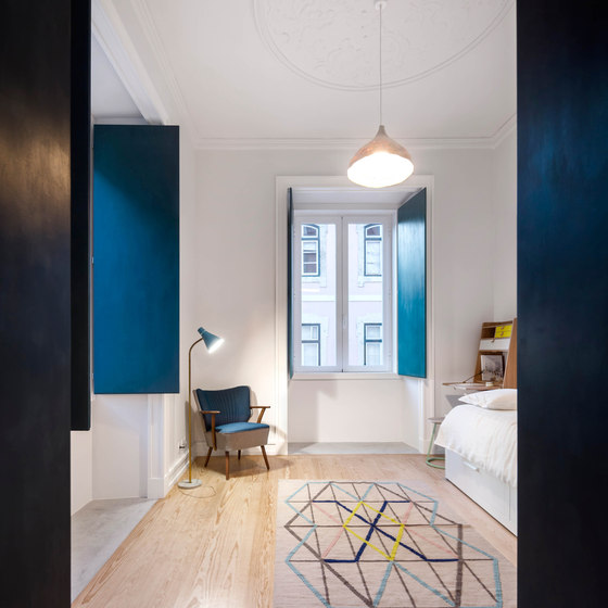 The use of shades of blue and a geometrical rug in this room makes it unusual