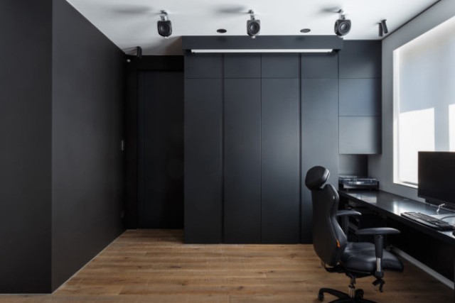 14 The home office is clad with dark panels, which hide everything until the owner needs it