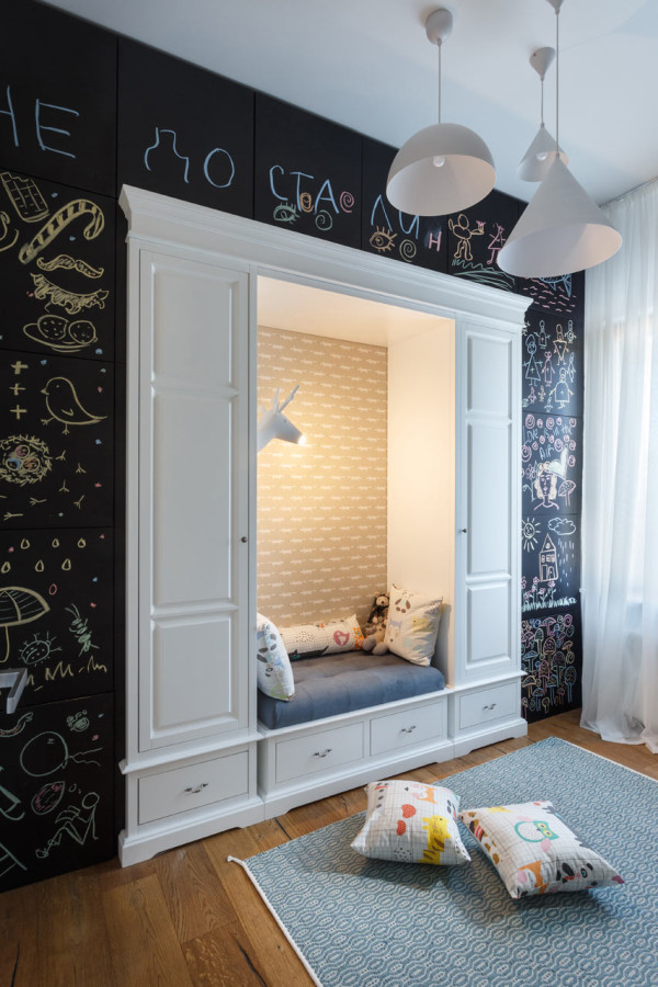 A cozy reading nook for the kid is inserted into a chalkboard wall, which hides cabinets