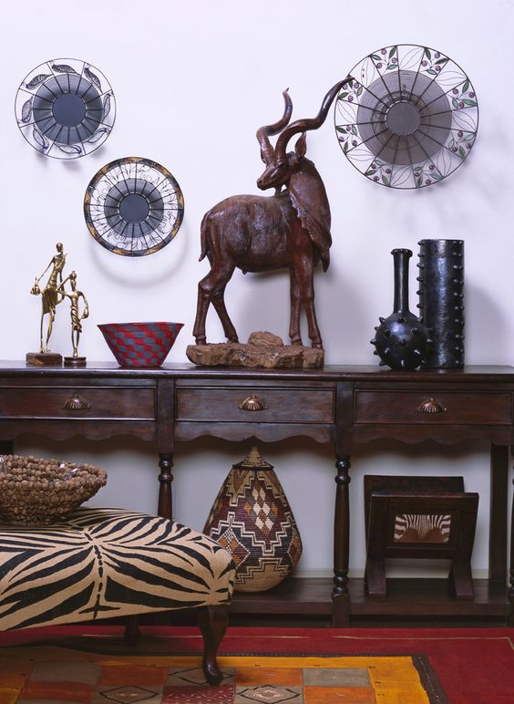 Carved console table with a zebra printed ottoman and African artworks