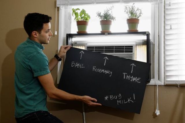 LOS ANGELES, CALIFORNIA - AUGUST 1, 2013: Interior designer Kyle Schuneman demonstrates his project, an air conditioning cover and planter in an apartment in Los Angeles on August 1, 2013. (Gary Friedman/Los Angeles Times)