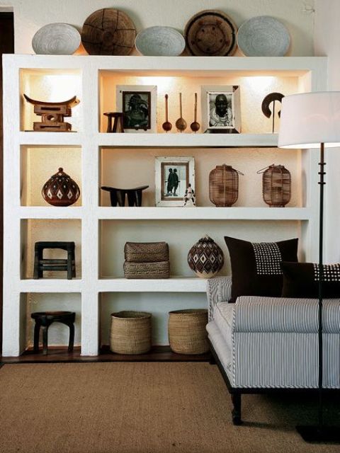 23 African pottery and wooden bowls displayed on shelves with hidden lights