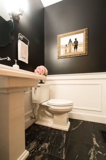 traditional powder room with a high ceiling, black walls and white wainscoting