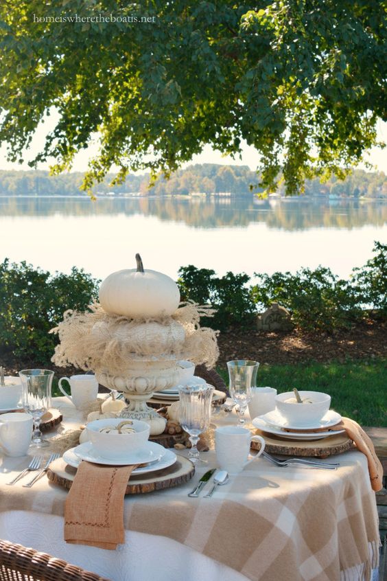 wooden slices as chargers, plaid tablecloths, a white pumpkin in a pot as a centerpiece