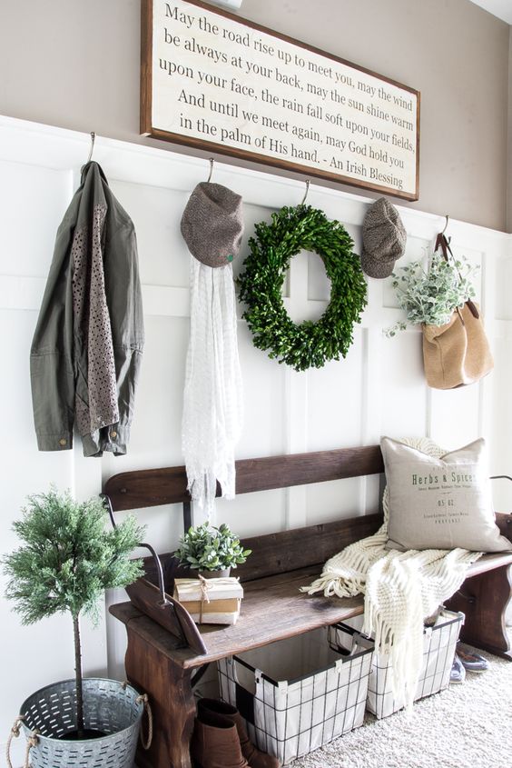 farmhouse entryway with white wainscot and hooks on it