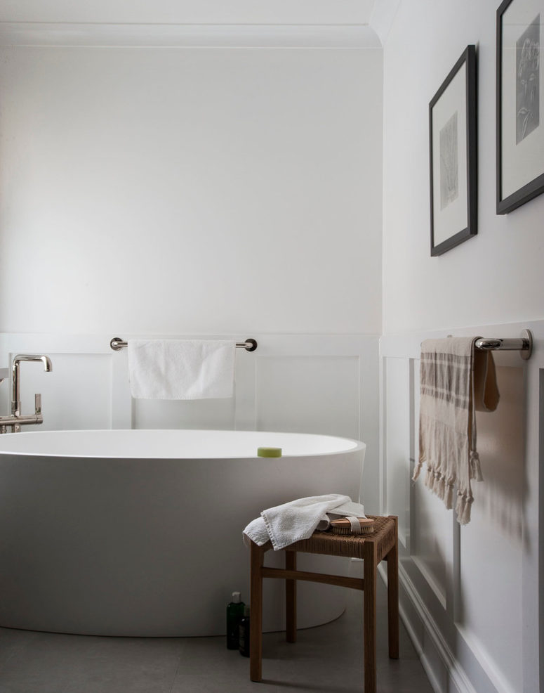 Water resistant wainscoting is a perfect addition to a modern plain white bathroom. (indi interiors)