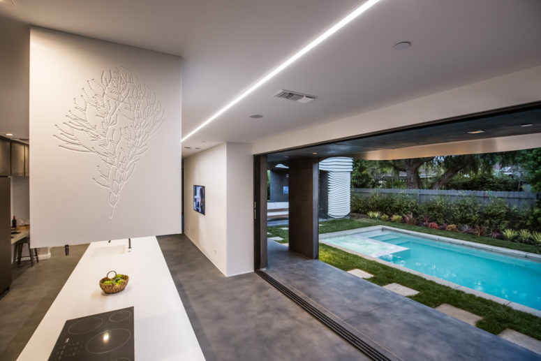 The minimalist and functional kitchen can be merged with the garden if the owners open a large door