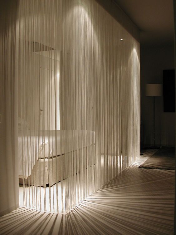 fringe curtains that are lit up are a perfect divider for modern and minimalist homes