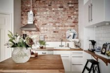 02 rough brick wall creates a bold accent in this modenr white kitchen and makes it look cool