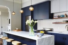 04 a waterfall countertop gives this modern navy kitchen a sleek and clean look