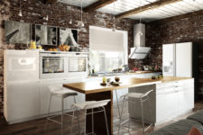 05 The kitchen is modern and even minimalist, the cabinets are white with light wood countertops