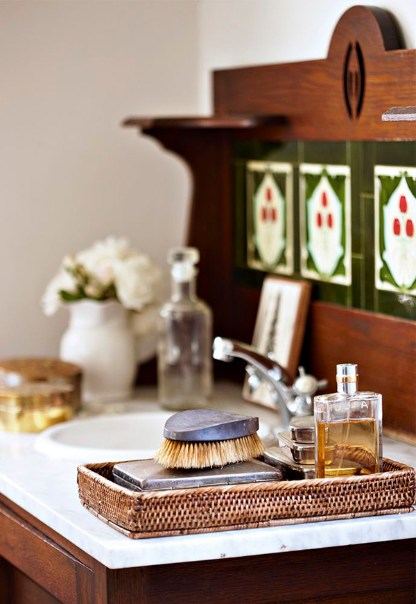 The sink space features an antique stand and some natural accessories that create a luxurious and spa-like look