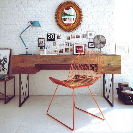 mid-century modern home office with a boho flavor is complemented with a white brick wall