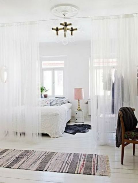 sheer tulle curtains divide the sleeping area and closet space from the rest of the home
