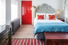 09 The master bedroom looks like a bold artwork, there’s a bold red door, a vintage radiator, oriental textiles and a headboard