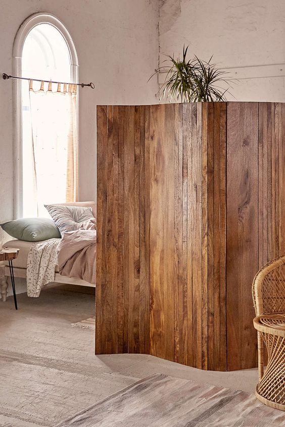 slatted screen room divider adds a natural touch to the room decor