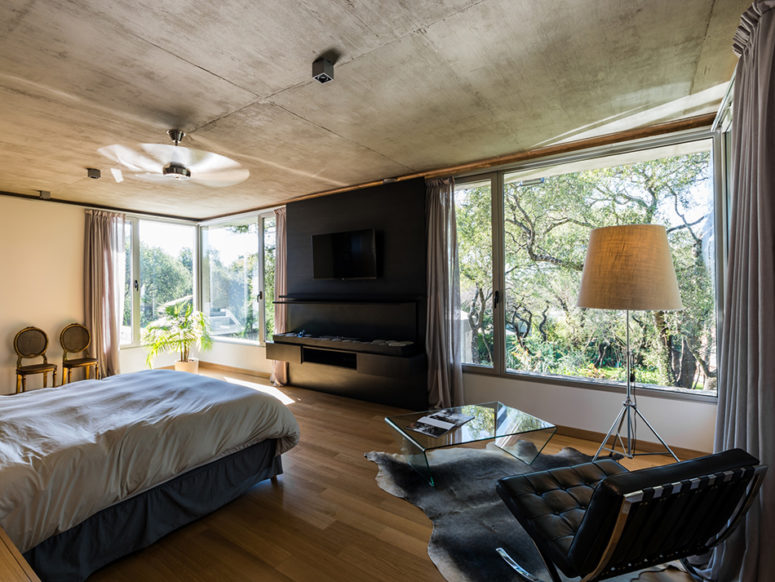 the bedroom is also highlighted with black and there are large windows to capture the views