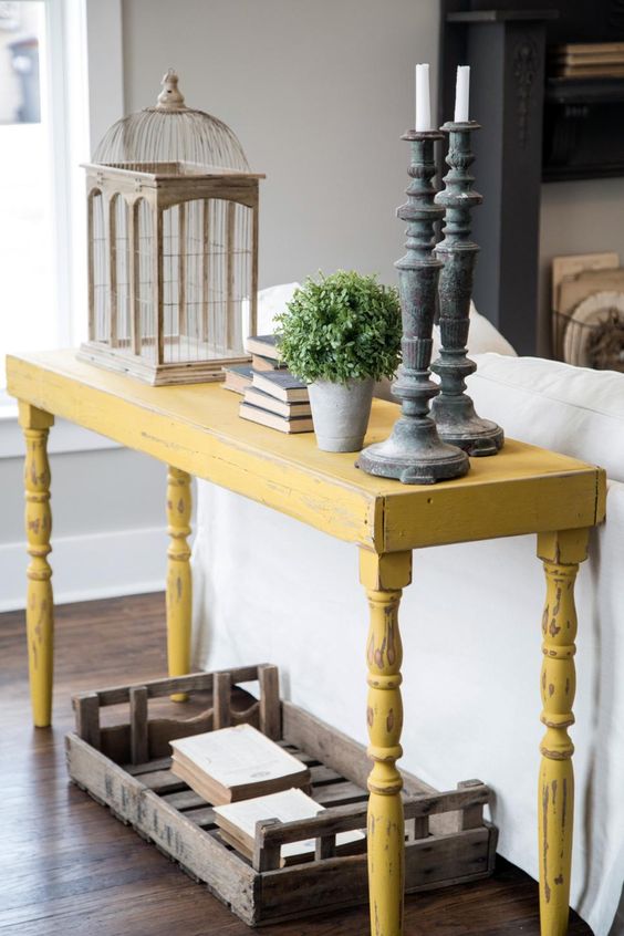 a distressed yellow onsole table will stand out in a grey living room