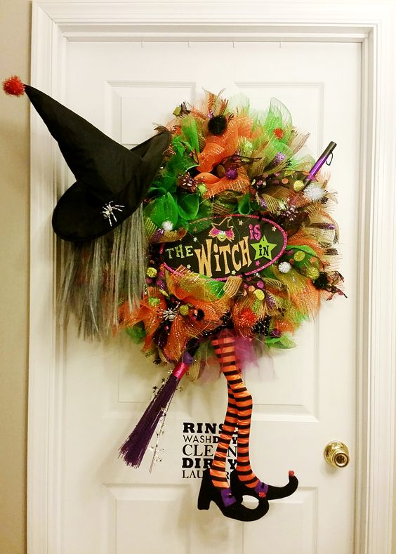 bold deco mesh wreath with a hat and legs is a simple idea sutiable for every Halloween