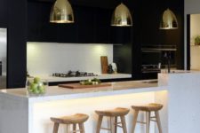 13 minimal black cabinets dominate this kitchen and a white kitchen island creates a contrast