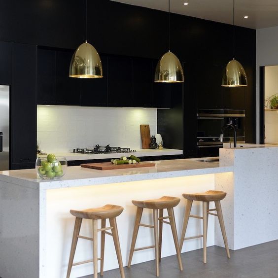 minimal black cabinets dominate this kitchen and a white kitchen island creates a contrast