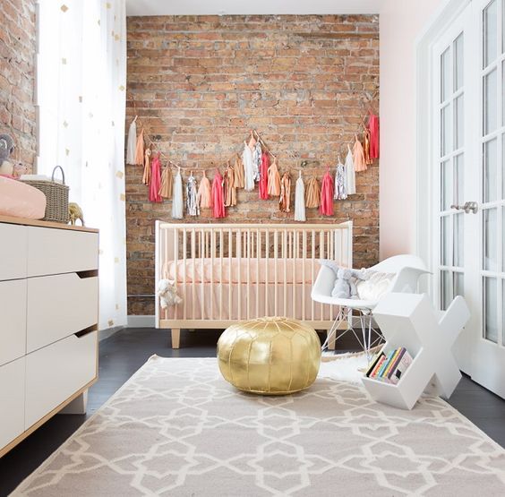 a little one’s nursery is given extra character when focused on the exposed brick wall
