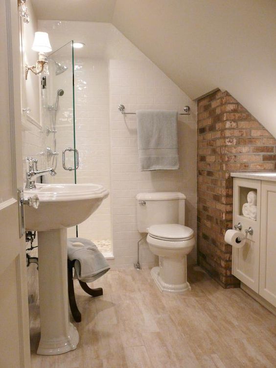 a piece of brick wall adds to the simple decor of this bathroom