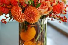 17 orange dahlias, roses, berries and pumpkins inside the glass vase