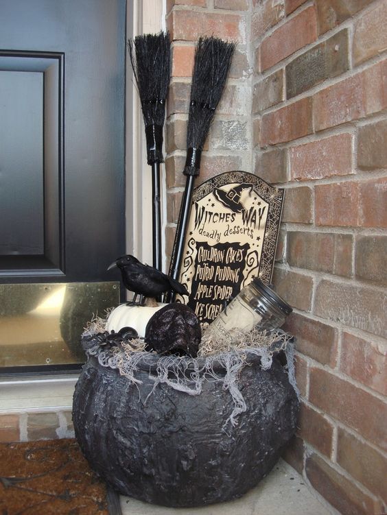 cauldron with witch's supplies instead of flower containers at the door