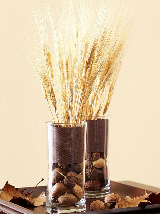 glass vases filled with various nuts and wheat, with fabric stripes