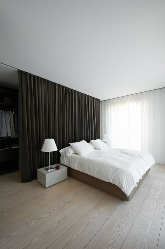 this heavy black curtain separates a man bedroom from an open closet