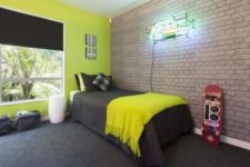 24 exposed brick highlights that it’s a boy’s room and contrasts with neon
