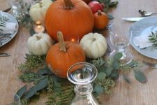 24 natural pumpkins with greenery and leaves placed right on the table