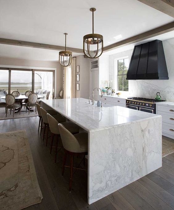 29 enjoy the durability of marble using it not only for a waterfall countertop but also for backsplashes