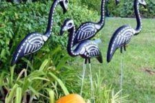 31 black skeleton flamingos and a pumpkin will make your Halloween bold