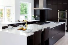 34 modern black and white kitchen with light-colored wooden floors and a steel hood