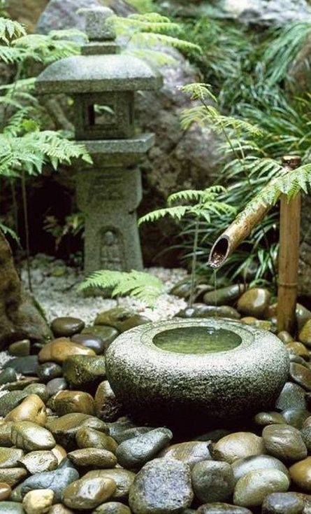 traditional Japanese bamboo fountain and large pebbles around