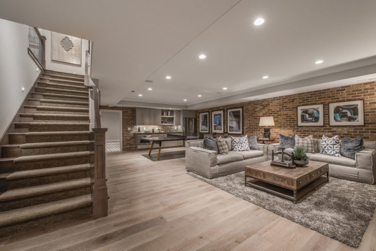 a brick wall is a natural choice for a basement living room (Walker Home Design)