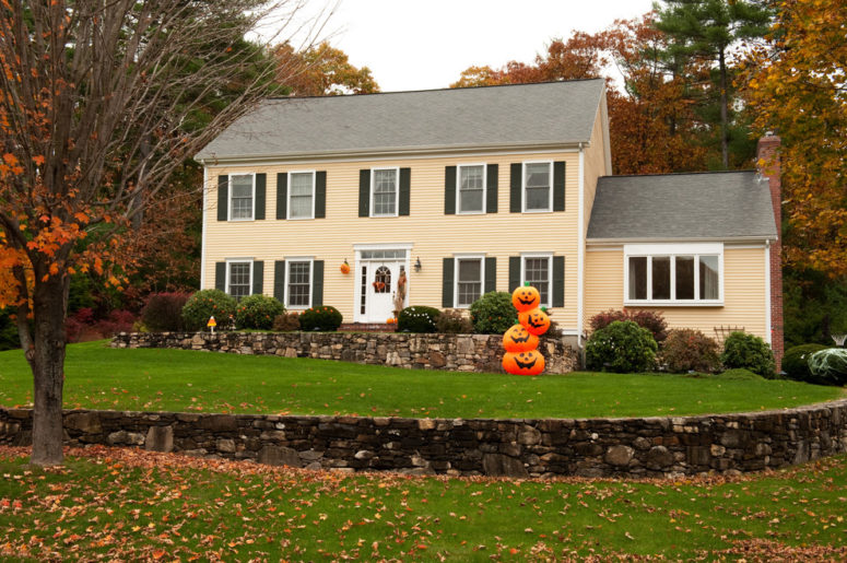 a stack of pumpkins with scary faces would welcome trick or treaters with style