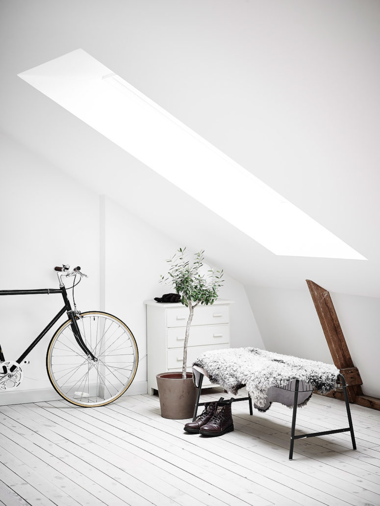 The entryway is filled with light through the attic window, the bench is covered with fur for comfort