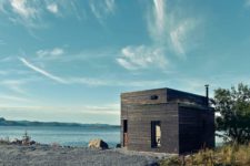 01 This dark wooden cabin is located on a northern coast, and it features Scandinavian design with some coastal touches